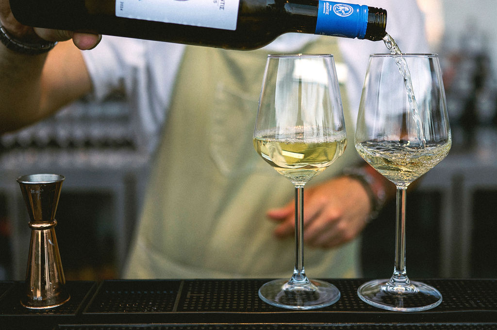 man filling the glasses with wine